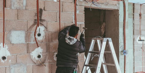 Electrician installing wiring during building renovation in Türkiye.