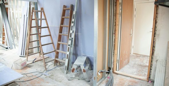 Construction site featuring ladders and tools in a home renovation setting.